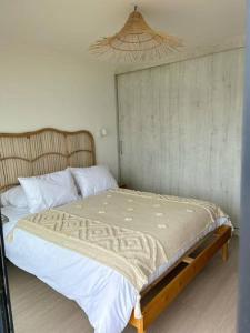 1 dormitorio con 1 cama grande con sábanas blancas en Cuatro Islas Lodge del Mar Cabaña Isla Damas, en Choros