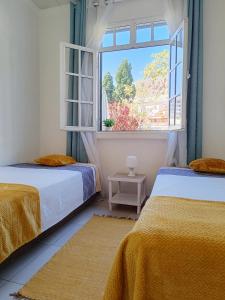 フンシャルにあるHome & Flower - Private bedrooms Funchalの窓付きの部屋 ベッド2台