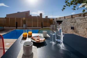 un tavolo con bicchieri e un piatto di cibo sopra di Flos Apartments a Korakiaí