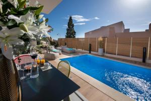 patio con tavolo e piscina di Flos Apartments a Korakiaí