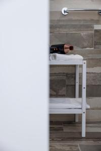 a white shelf with a bottle of wine on it at Essentia Rooms & Relax in Vasto