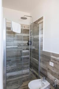 a bathroom with a shower with a toilet and a sink at Essentia Rooms & Relax in Vasto