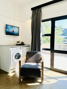 a living room with a washing machine and a chair at JHB City Living 119 - fibre Wi-Fi, washing machine & big sunny balcony in Johannesburg