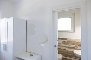 a white bathroom with a toilet and a sink at Essentia Rooms & Relax in Vasto