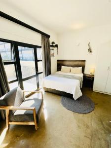 een slaapkamer met een bed en een stoel bij JHB City Living 119 - fibre Wi-Fi, washing machine & big sunny balcony in Johannesburg