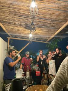 yaqtahostel في تروخيو: مجموعة من الناس تقف حول طاولة الشرب