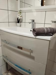 een witte badkamer met een wastafel en een handdoek bij Maison d'hôtes le clos de la Presle, Compostelle in Saint-Georges-Haute-Ville
