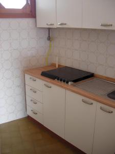 uma cozinha com armários brancos e uma bancada em Apartment Renata 26 em Lido di Jesolo