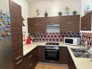 eine Küche mit Holzschränken und einer Mikrowelle in der Unterkunft Apartman c.8 Magnolie in Třeboň