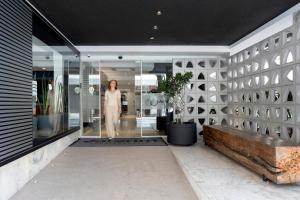 a woman walking through a glass door in a building at Valerim Florianópolis in Florianópolis