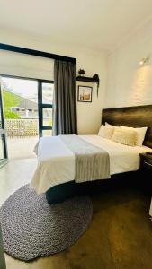 a bedroom with a large bed and a large window at JHB City Living 119 - fibre Wi-Fi, washing machine & big sunny balcony in Johannesburg