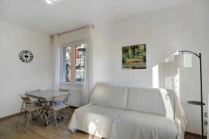 a white living room with a couch and a table at Ninfea apartments in Sanremo