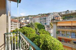 un balcone di un edificio con alberi e edifici di Ninfea apartments a Sanremo