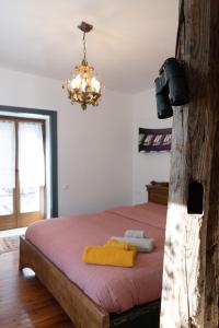 a bedroom with a bed and a chandelier at Casa Vacanze Zummer Frei Studio in Pieve di Cadore