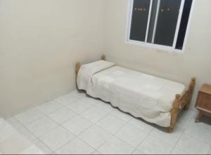 uma cama num quarto branco com uma janela em El Sauce em Albardón