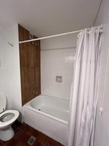 a bathroom with a white tub and a toilet at Departamento vista al mar in Necochea