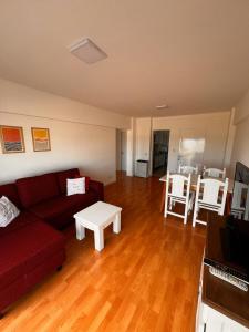a living room with a red couch and a table at Departamento vista al mar in Necochea +7 photos