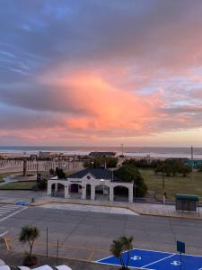 a building in a parking lot next to the beach at Departamento vista al mar in Necochea