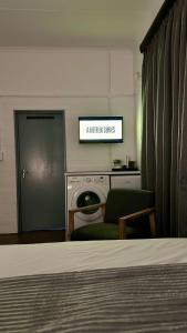 een woonkamer met een bed en een bord waarop staat dat de keuken verschuift bij JHB City Living 119 - fibre Wi-Fi, washing machine & big sunny balcony in Johannesburg