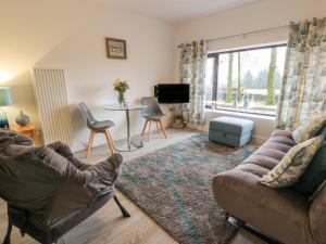 ein Wohnzimmer mit einem Sofa und einem Tisch in der Unterkunft Hollys Hideaway in Castle Douglas