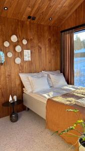 a bedroom with a bed and a wooden wall at Guesthouse with sauna & hot tub & cold water pool in Nokia