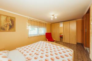 1 dormitorio con 1 cama y 1 silla roja en Holiday Homes I&G next to Olimje, en Kozje