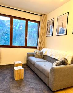 a living room with a couch and two windows at Ecrin Alpin hyper centre d'Auron in Saint-Étienne-de-Tinée