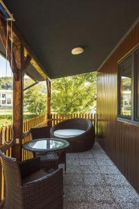 d'un balcon avec 2 tables et des chaises et une baignoire. dans l'établissement Holiday Homes I&G next to Olimje, à Kozje
