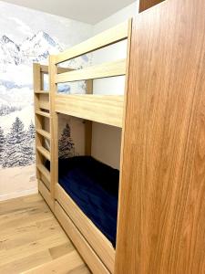 a wooden bunk bed in a room with snow covered mountains at Ecrin Alpin hyper centre d'Auron in Saint-Étienne-de-Tinée