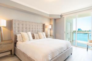 a bedroom with a large white bed with a large window at Golden Bay 808 in Miami Beach +42 photos