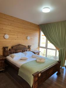 um quarto com uma cama grande e uma parede de madeira em Olko House em Yaremche