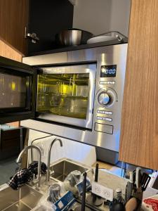 a microwave oven in a kitchen with a sink at Ecrin Alpin hyper centre d'Auron in Saint-Étienne-de-Tinée