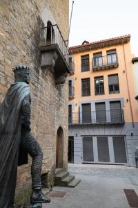 a statue of a man standing next to a building at Apartamentos Torre del Reloj in Jaca