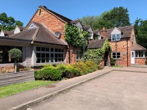 a brick house with a driveway in front of it at The Punchbowl Lapworth in Solihull