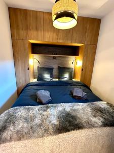 a bedroom with a large blue bed with a wooden headboard at Ecrin Alpin hyper centre d'Auron in Saint-Étienne-de-Tinée