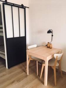 a table with two chairs and a lamp next to a door at Studio Saint Cyr sur mer,Vue mer in Saint-Cyr-sur-Mer