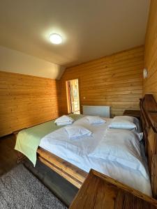 um quarto com uma cama grande numa parede de madeira em Olko House em Yaremche