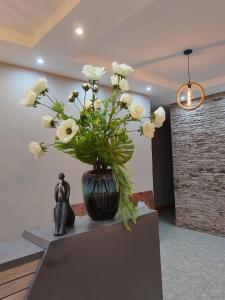 a vase filled with white flowers sitting next to a statue at Boontjieskraal in Kimberley