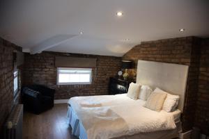 um quarto com uma cama grande e uma parede de tijolos em Richmond Apartment em Liverpool