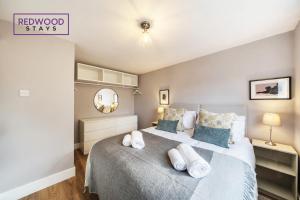 a bedroom with a bed with pillows and a mirror at 2 Bed 1 Bath House, Perfect for Corporate, Contractors & Families x2 FREE Parking, Garden, Netflix By REDWOOD STAYS in Alton