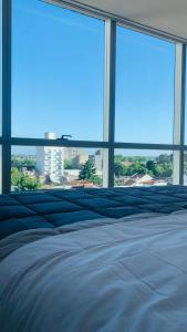 1 cama grande en una habitación con ventanas grandes en Huésped Tandil en Tandil