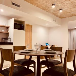 a dining room with a wooden table and chairs at Huésped Tandil in Tandil +3 photos