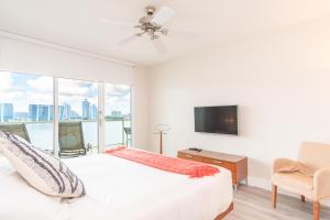 een slaapkamer met een bed, een tv en een raam bij Marina Bay 108 in Miami Beach