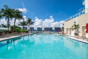 a large swimming pool with palm trees and a building at Marina Bay 46 in Miami Beach