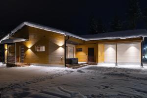 a house in the snow at night at Premium Lapland Villa with jaguzzi in Rovaniemi