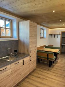 a kitchen with a sink and a table in a room at Wirtshäusl Maria Alm in Maria Alm am Steinernen Meer