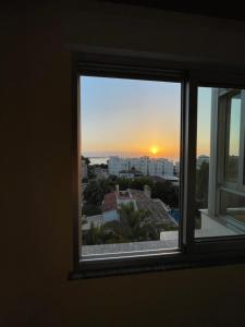 una ventana con vistas a la puesta de sol en Seaview 4 Star Beach Apartment, en Denia