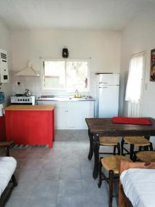 a kitchen with a wooden table and a red island at Los Leones in La Cumbre