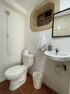 a bathroom with a toilet and a sink at Zoola Suites Antigua in Antigua Guatemala