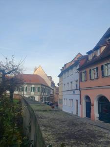 a group of buildings on a street next to a wall at BeckHomes: Luxuriöses Juwel mitten in der Altstadt in Bamberg